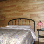 The main bedroom of our cabin for rent features a queen size bed, closet, dresser, and nightstand!